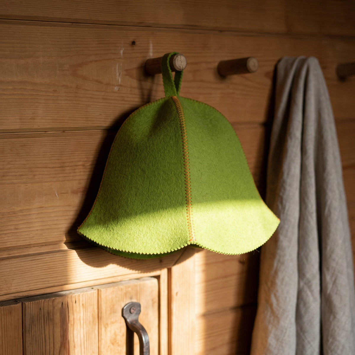 Traditional Lightweight Green Felt Sauna Hat - hanging on a sauna peg