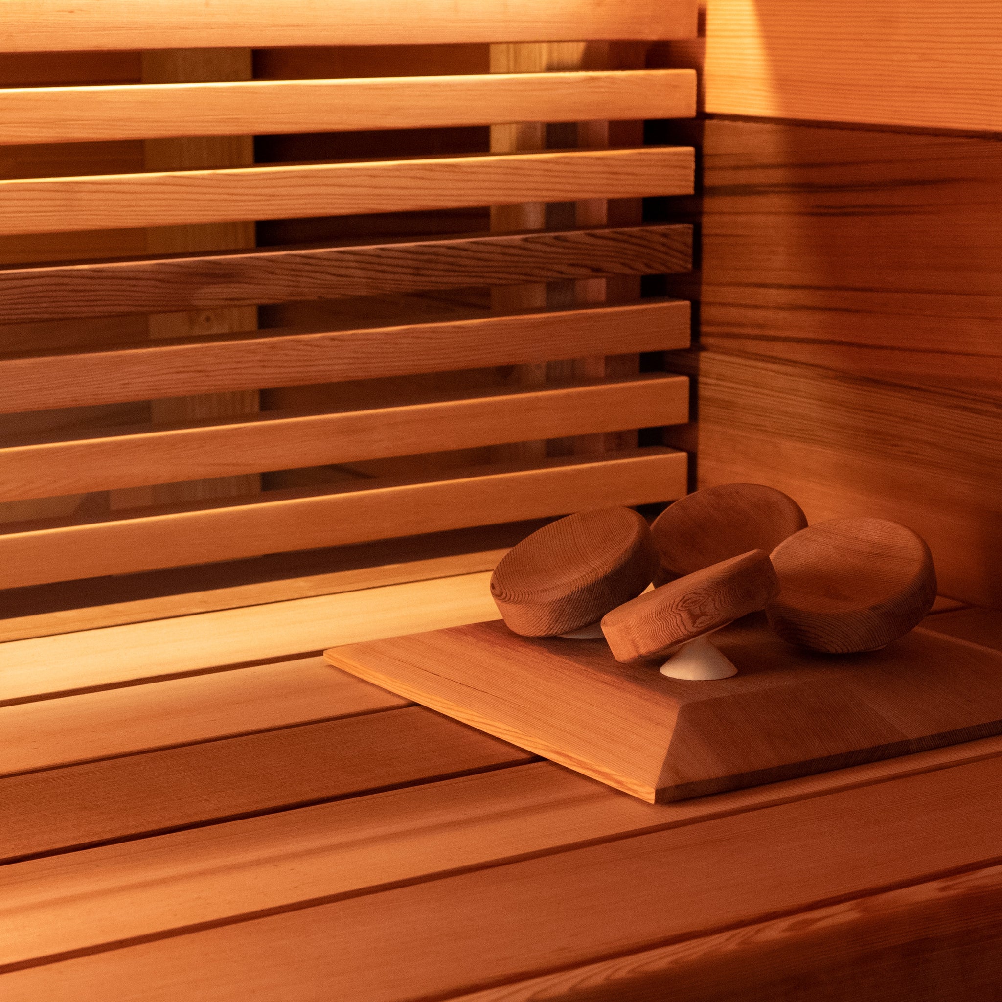 Western Red Cedar Sauna Installation with wide cedar cladding and sauna bench with slatted skirting. Pivoting Halu sauna headrest in western red cedar is also visible.