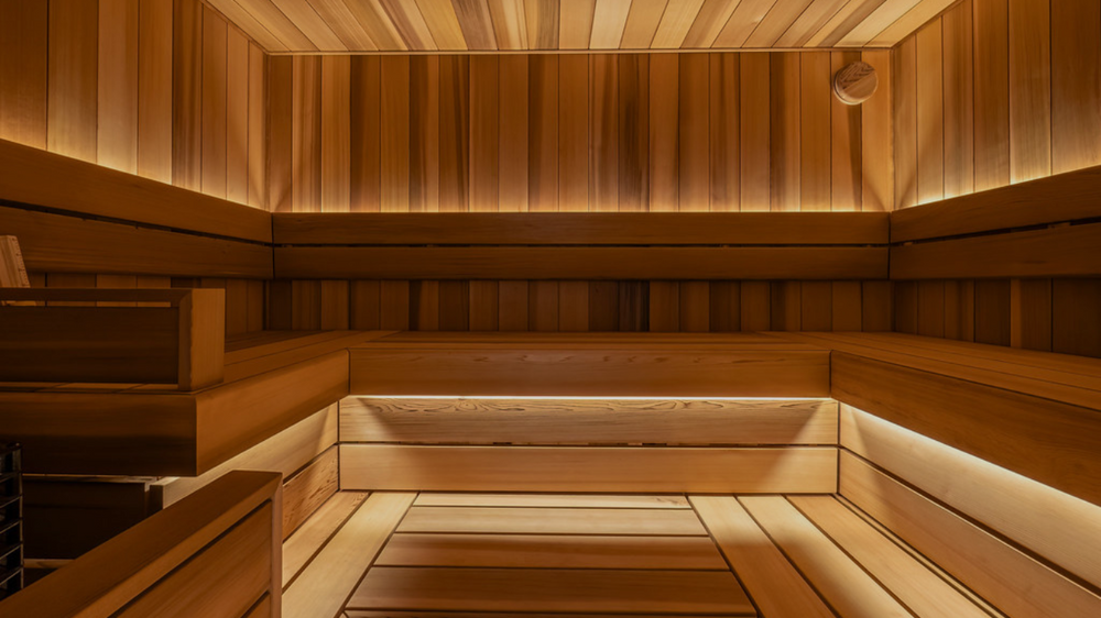 Wooden sauna interior with benches and warm lighting