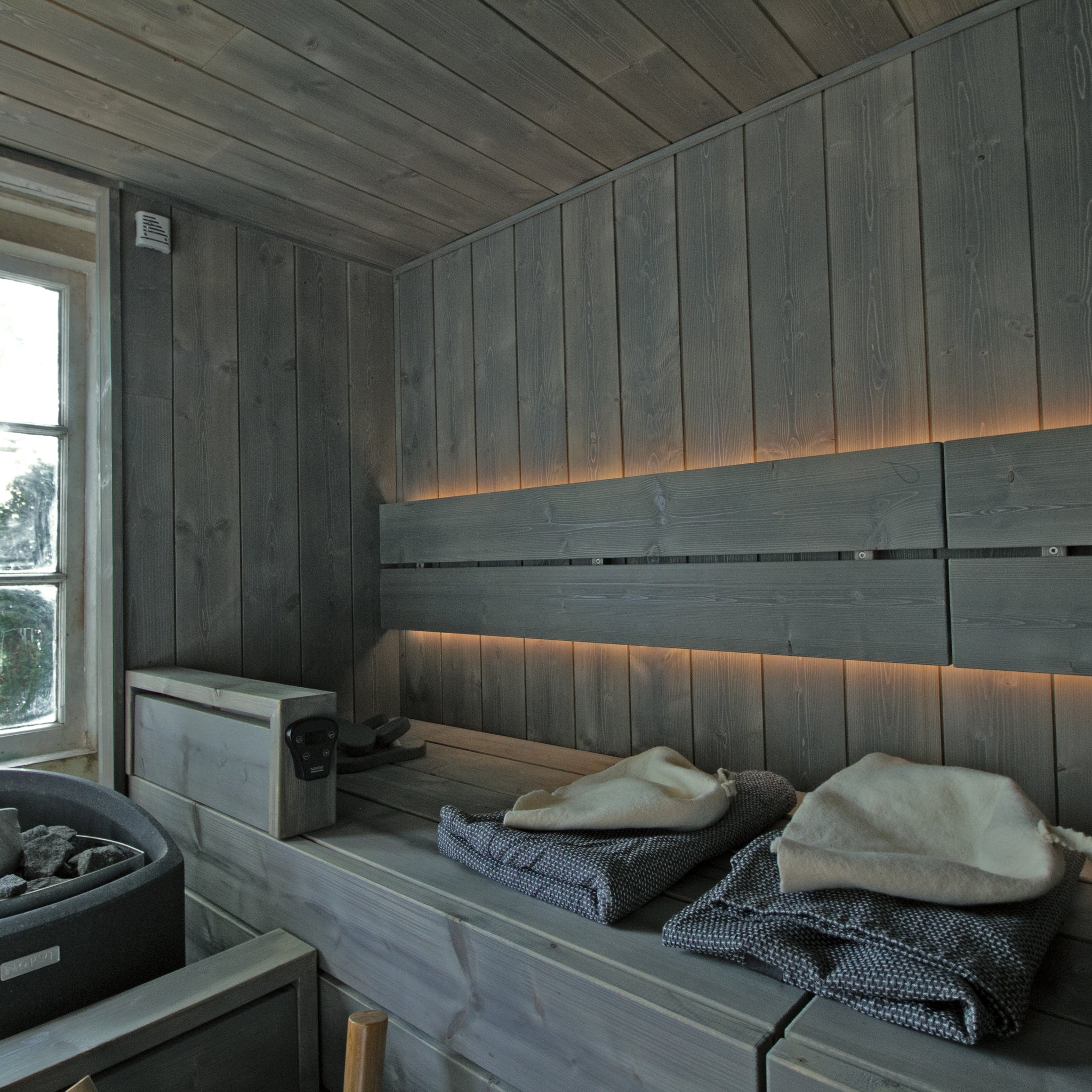 Bespoke Sauna Installation by Finnmark Sauna using brushed spruce. The sauna wood is grey due to the use of Grey Supi Sauna Wax. The sauna heater is a Narvi Trio electric sauna heater.