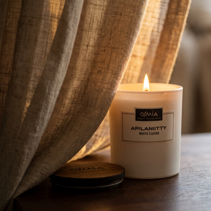 White Clover Scented Candle by Osmia - lit behind linen curtain