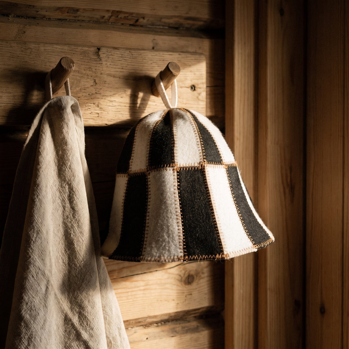 Sauna Hat Black/White (Polyester Felt) - hanging on a sauna peg