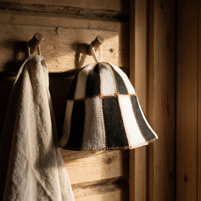 Sauna Hat Black/White (Polyester Felt) - hanging on a sauna peg